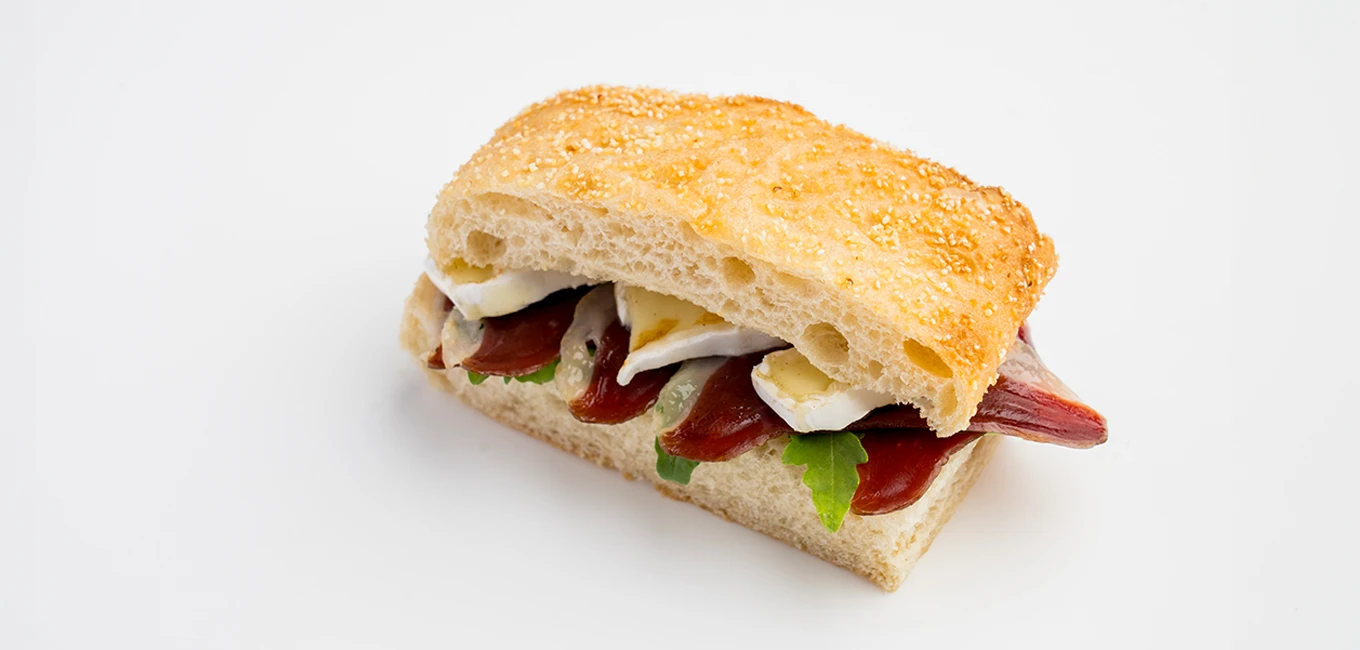 Mini sandwich de focaccia, queso brie y jamón de pato