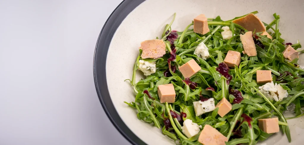 Ensalada de foie gras mi-cuit, rúcula, queso azul y vinagreta de arándanos