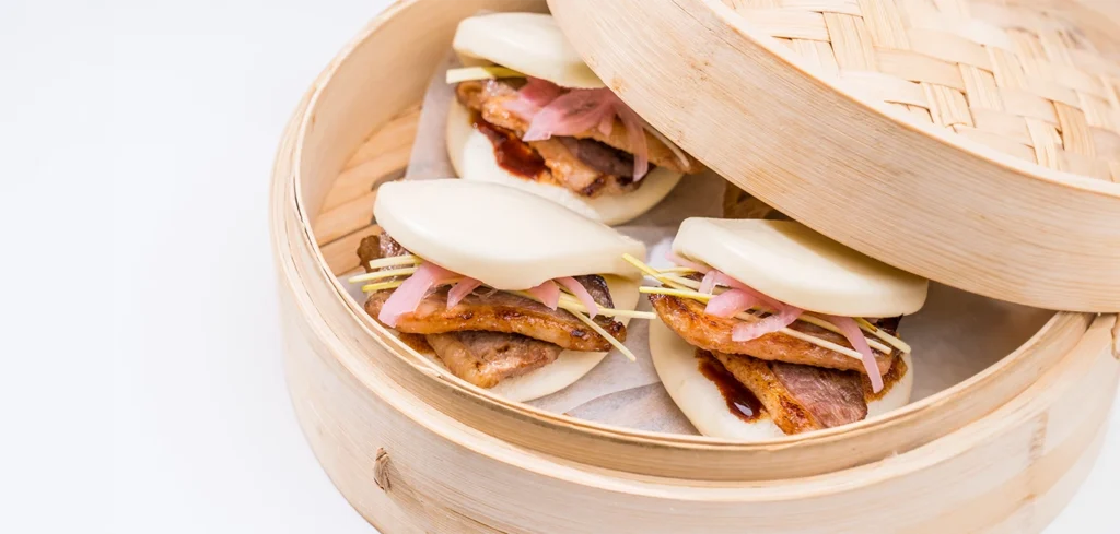 Pan bao relleno de magret de pato, salsa asiática y cebolla encurtida