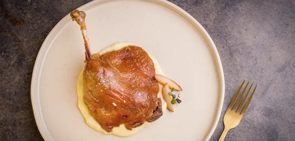 Muslo de pato confit con parmentier de patata y ajo asado