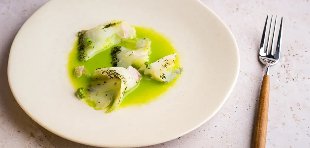 Bacalao ahumado sobre crema fría de guisantes y menta