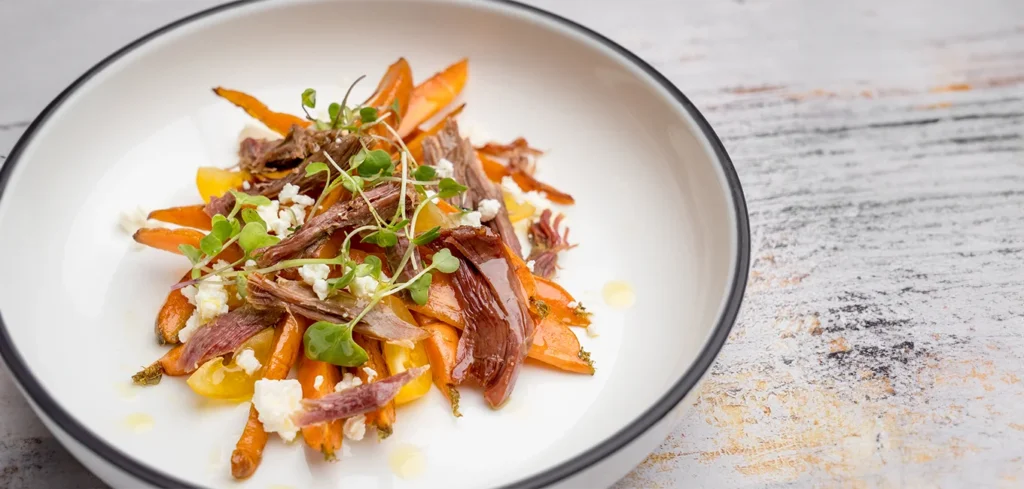 Ensalada templada de zanahoria asada, pato desmigado, canónigos y queso feta